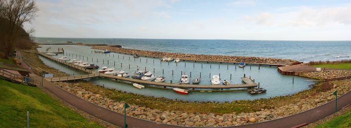 Small yacht port with pier. sailboat harbor, many moored sail yachts in the sea.