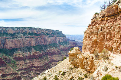 Rock formations on mountain against cloudy sky