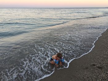 High angle view of boy on beach against sky