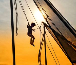 Low angle view of man jumping on rope against sky