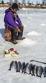 Rear view of a fisher in winter