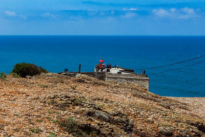 High angle view of nazare cannon and lighthouse with sea against sky