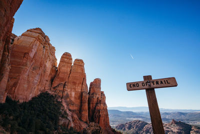 Information sign on rock against sky