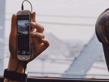 Cropped image of woman photographing through smart phone