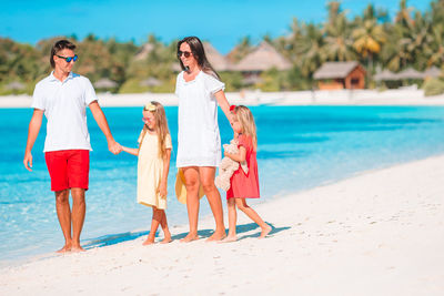 Full length of family standing on beach