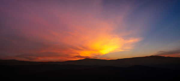 Scenic view of silhouette mountains against sky during sunset