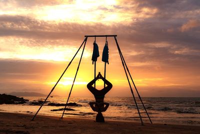 Silhouette person on beach against sky during sunset