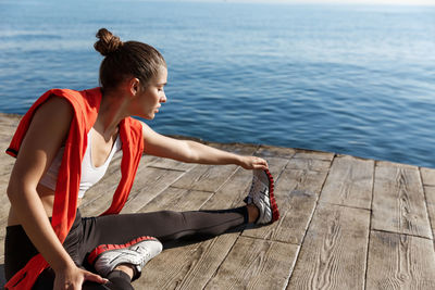 High angle view of woman exercising by sea