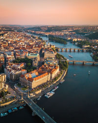 Aerial view of buildings by river against sky