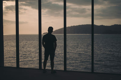 Rear view of silhouette man looking at sea