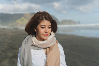 Portrait of young woman standing on beach