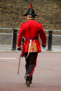 Rear view of man walking on red road