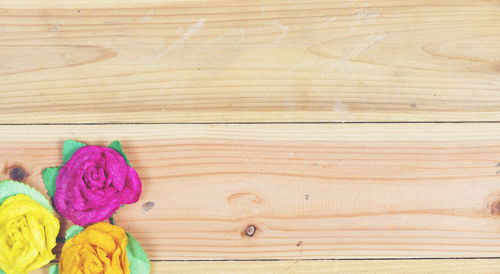 Directly above artificial roses on wooden table