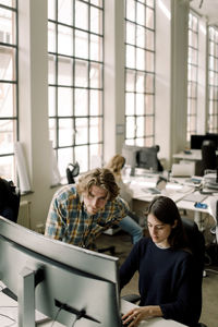 Businessman and businesswoman working on computer in office