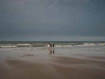 People on beach against sky