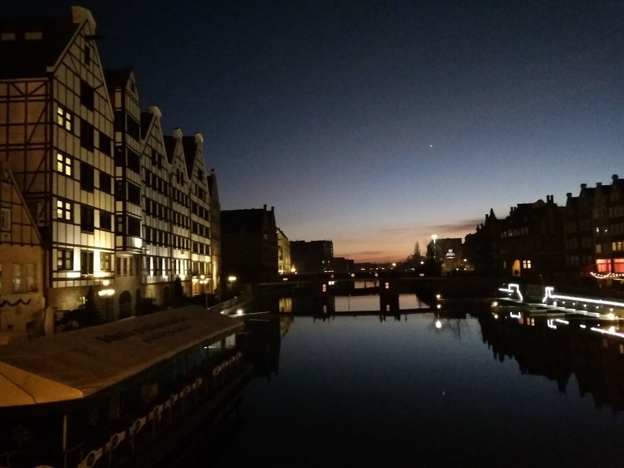 REFLECTION OF ILLUMINATED BUILDINGS IN RIVER AT NIGHT