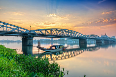 Bridge over river against sky during sunset