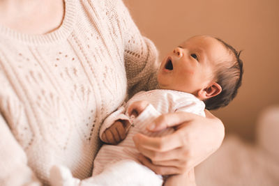 Close-up of cute baby girl lying on bed at home