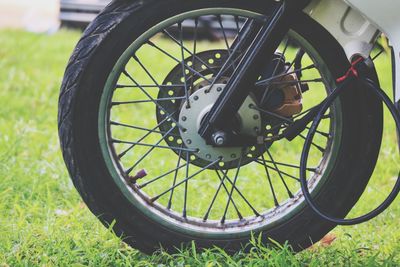 Close-up of bicycle wheel on field