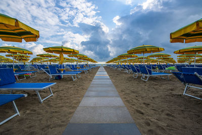 High angle view of chairs and tables and lounge chair against sky