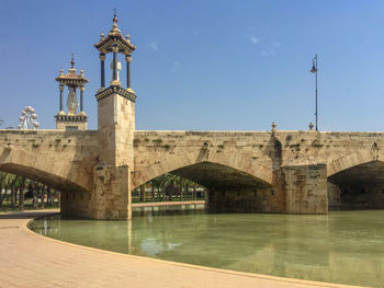 Arch bridge over river against sky