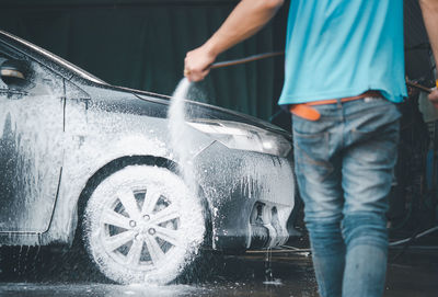 Low section of man cleaning car