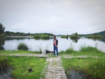 Man standing on lake against sky