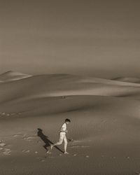 Woman on sand dune in desert