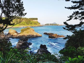 Scenic view of rocks in sea against sky