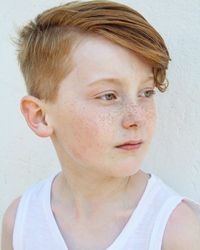 Close-up of boy looking away by wall