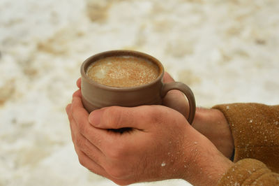 Close-up of hand holding coffee cup