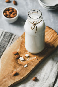 High angle view of milk and almonds on table