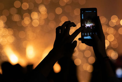 A person recording a fireworks show with his mobile phone