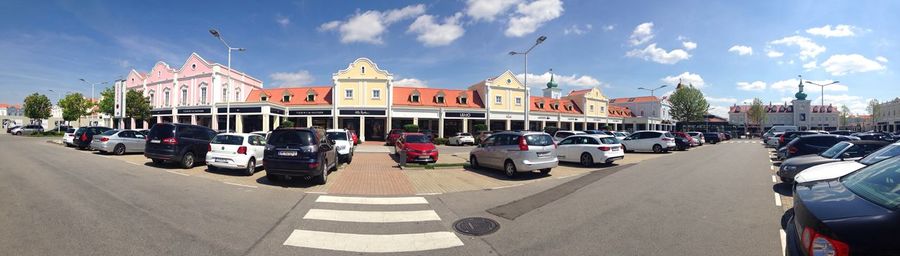 Cars on road in city against sky