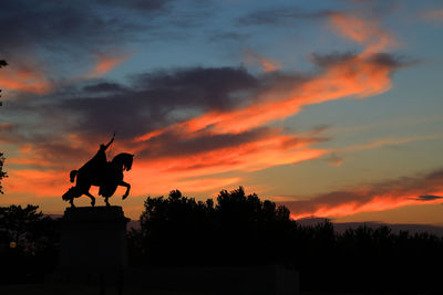 Low angle view of silhouette statue against sky during sunset
