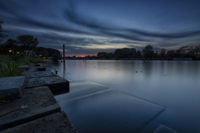 Scenic view of river against sky at sunset