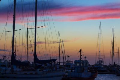 Boats moored at harbor during sunset