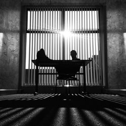 Businessman sitting against window in office