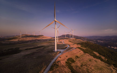 Wind turbines on land against sky