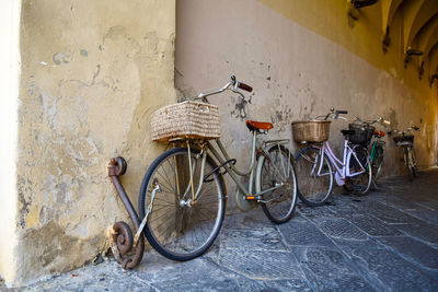 A row of bicycles parked under an old porch in the historic centre of lucca, toscany