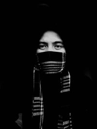 Portrait of young man against black background