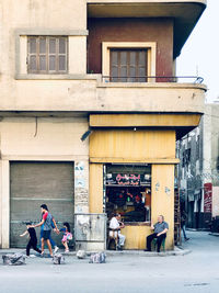 People on street against building in city