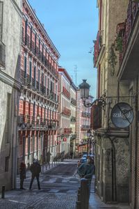 Street amidst buildings against sky in city