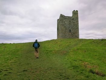 Rear view of man on field against sky