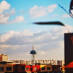 Buildings in city against cloudy sky