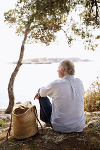 Rear view of senior man sitting looking at view