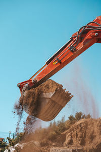 Low angle view of construction site against clear blue sky