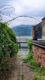 Footpath by river against sky