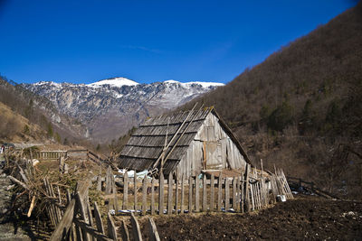 Old abandoned building by mountains against sky