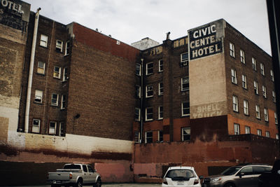 Cars on road by buildings against sky